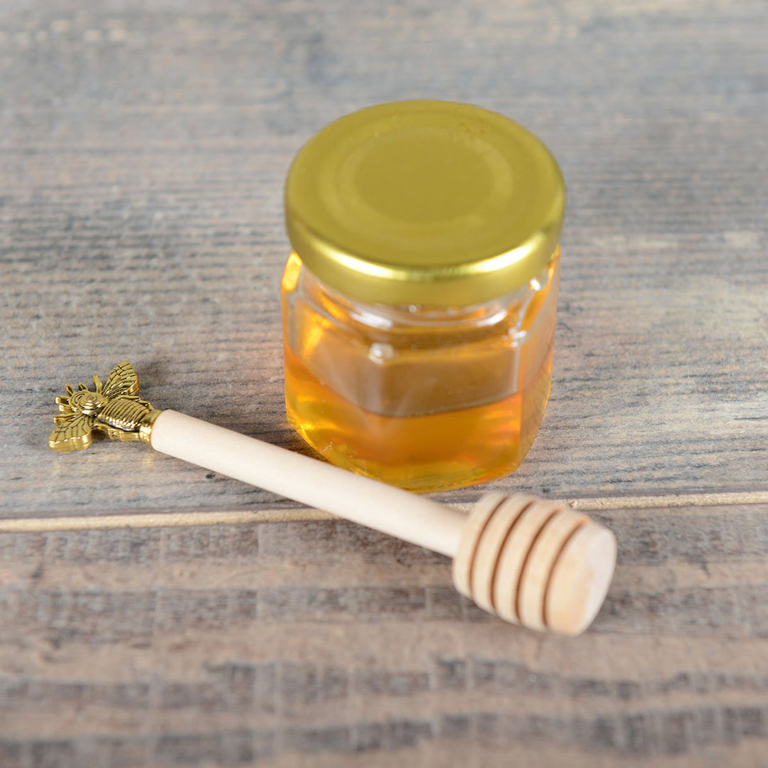 Cuillère à miel en bois avec abeille dorée